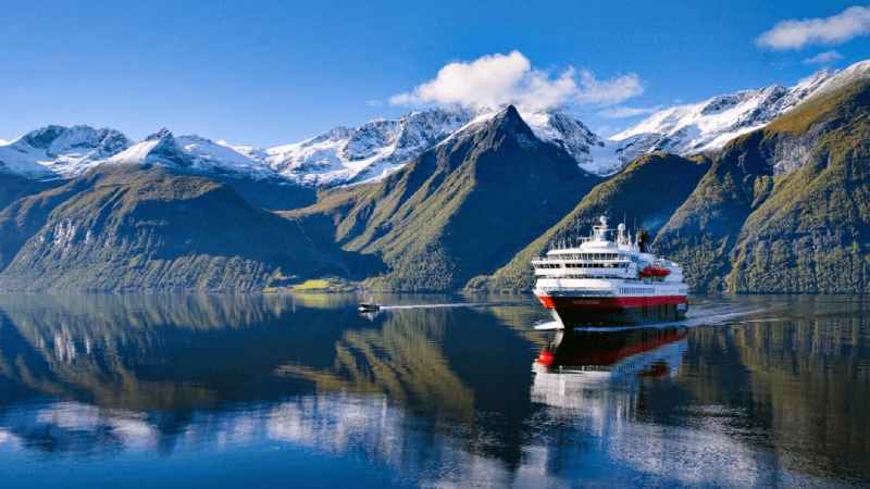Hurtigruten ship on the Norwegian coast with mountains in the background
