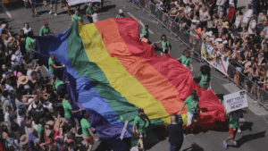 Toronto Pride Parade with a big pride flag being carried by volunteers