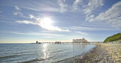Mecklenburg Western Pomerania, a beach with a pier and the sun shining on the water