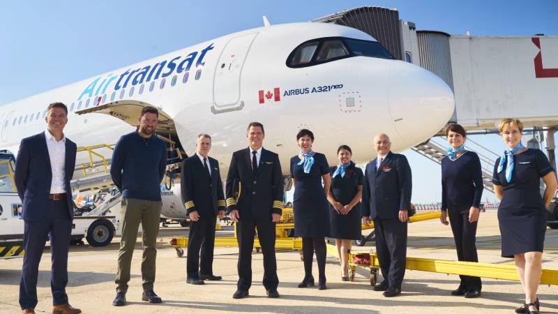 Air Transat staff posing in front of its new Airbus A321neoLR aircraft to celebrate its first flight from YYZ-LGW following a pandemic pause.