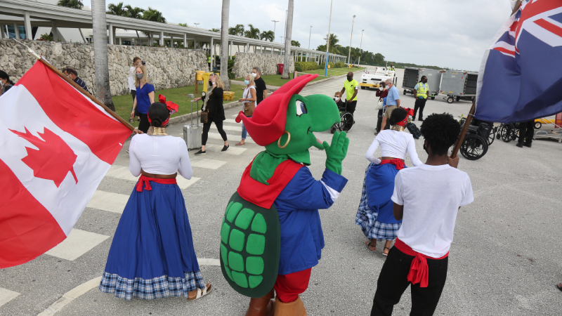 Cayman Islands' staff and Sir Turtle greeting Canadians