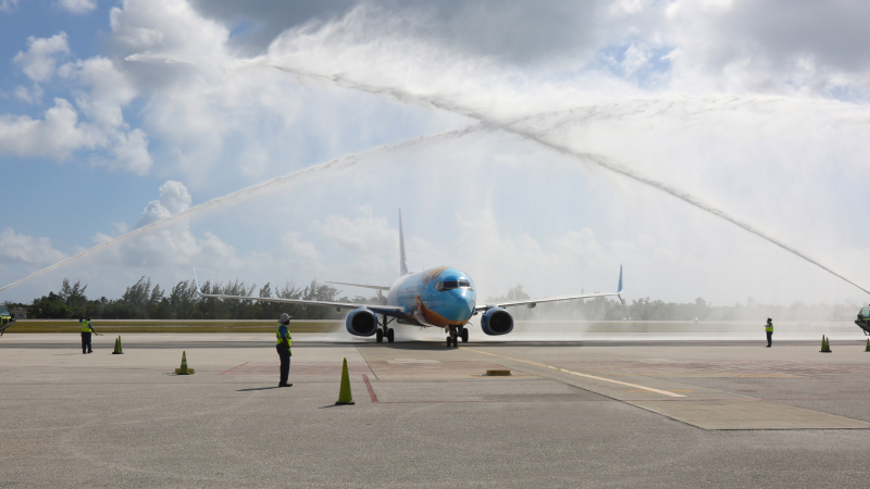 WestJet plane receiving a water salute upon arrival at GCM.