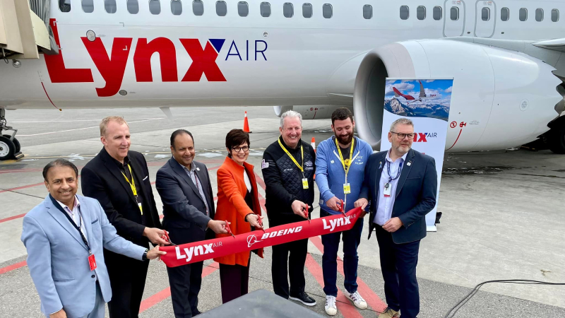 Lynx Air CEO Merren McArthur (middle) and other executives celebrating the airline's inaugural service to YLW.