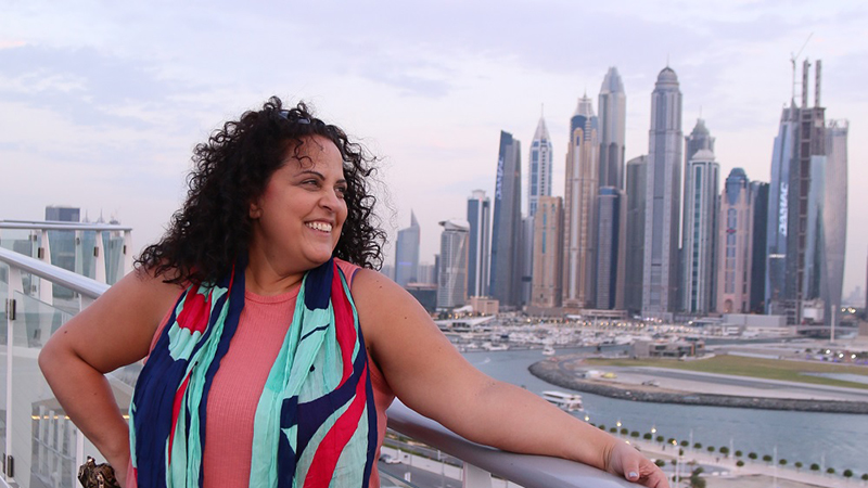 Karen Dahdah posing on the Costa Toscana skywalk overlooking Dubai Harbour