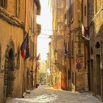 Tuscan sunset illuminates a medieval street in Cortona